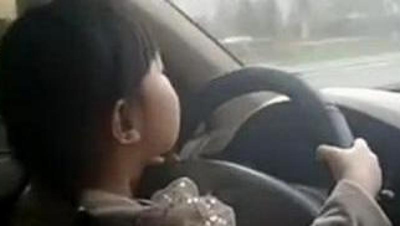 VIDEO! O fetita de 4 ani conduce masina pe o sosea aglomerata. Este filmata de mama ei