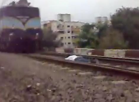 VIDEO! Vezi cum sfideaza moartea un indian: Se intinde pe calea ferata la trecerea trenului