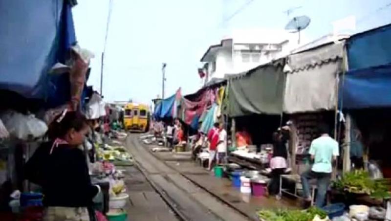 In Thailanda un tren circula prin mijlocul unei piete