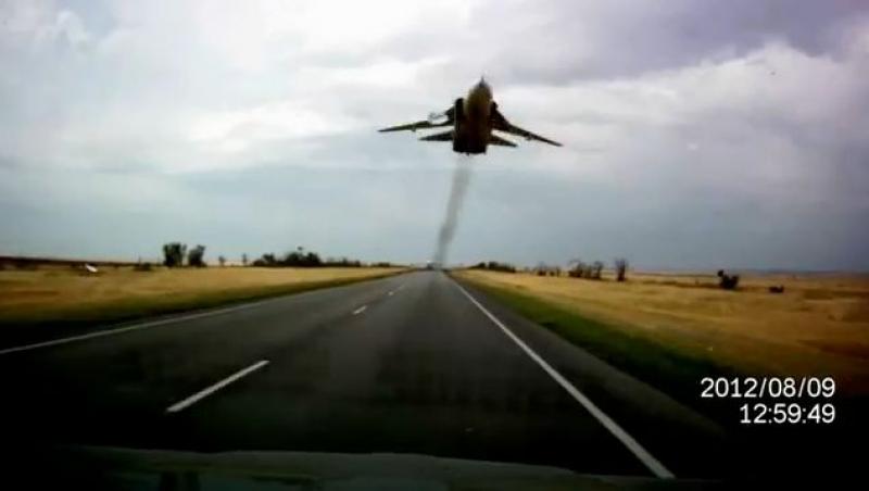 Un avion de lupta zboara razant peste o autostrada din sudul Rusiei