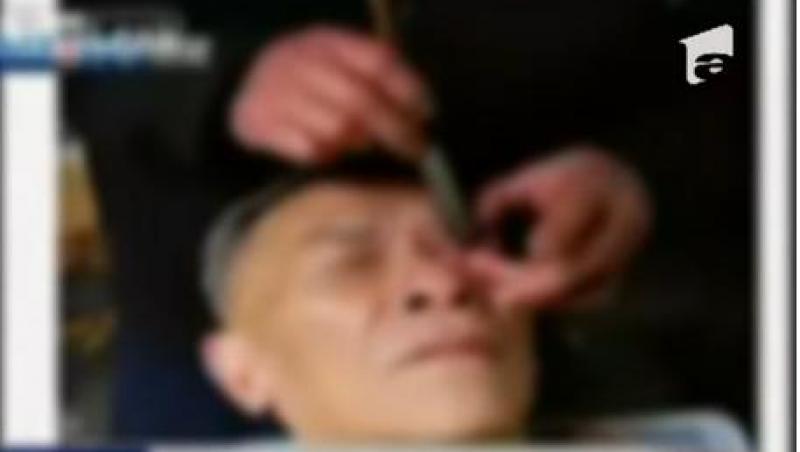 Socant! Un barbier din China le curata ochii clientilor cu briciul