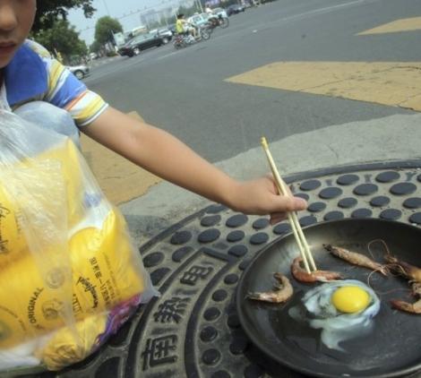 E fierbinte, frige, frige: chinezii fac omleta pe gura de canalizare!!!