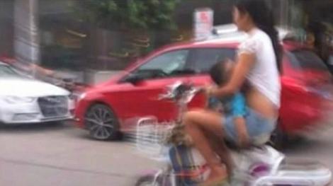 SOCANT! O femeie din China alapteaza bebelusul in timp ce conduce o motocicleta