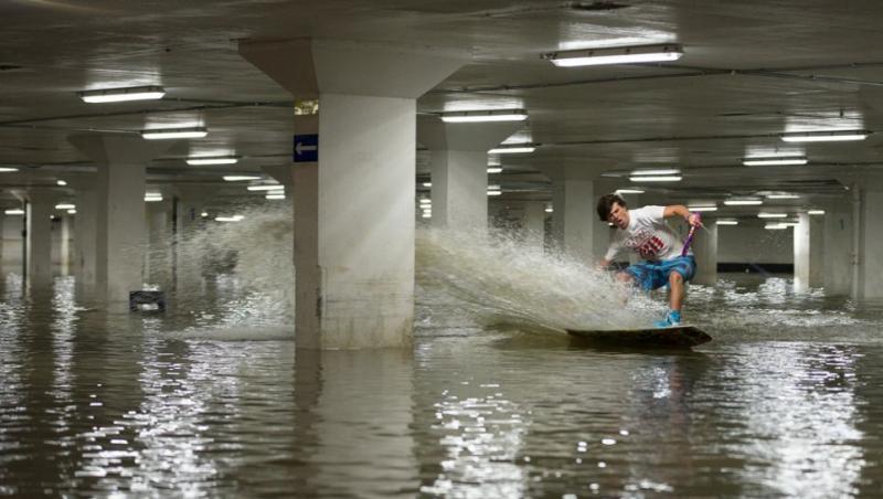 Au sfidat moartea! Câţiva tineri din Marea Britanie s-au aventurat cu plăcile de surf într-o parcare subterană inundată