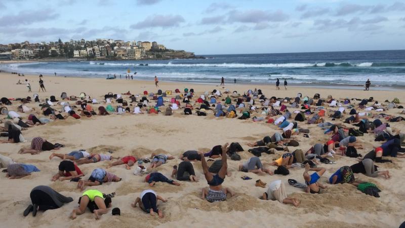 Imaginile care fac înconjurul lumii: Sute de australieni s-au îngropat în nisip, de bună voie! N-o să ghiceşti niciodată motivul pentru gestul şocant