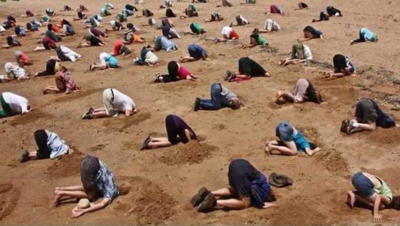 Imaginile care fac înconjurul lumii: Sute de australieni s-au îngropat în nisip, de bună voie! N-o să ghiceşti niciodată motivul pentru gestul şocant