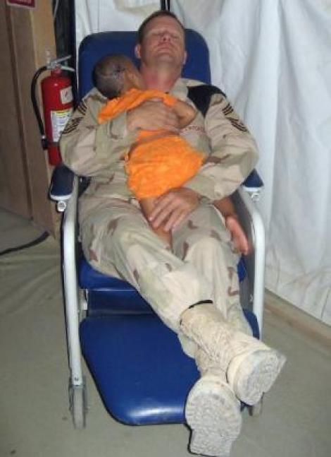 Emoționant. Un soldat american are grijă de o fetiță irakiană, împușcată în cap!
