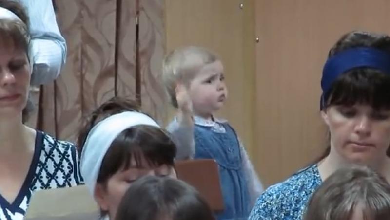 Este ADORABILĂ! O fetiță de doar trei ani dirijează un cor