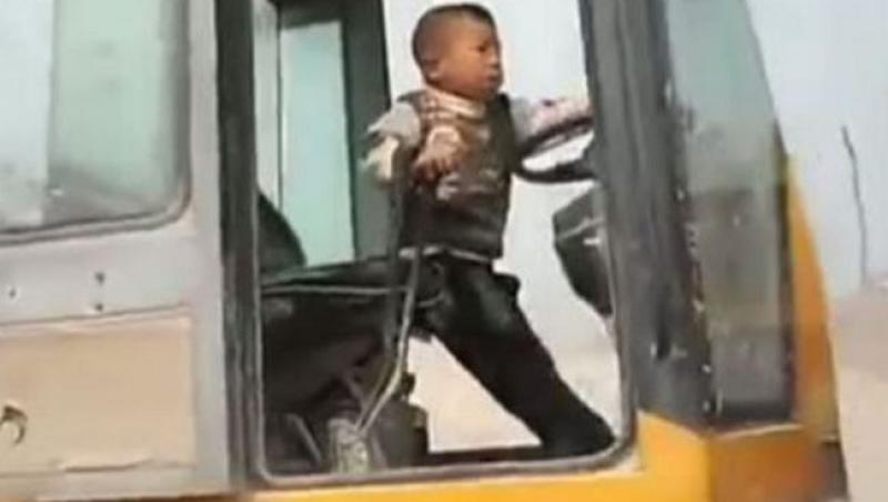 VIDEO! Un băiat de cinci ani manevrează excavatorul pe şantier