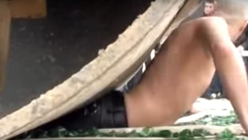 VIDEO ȘOCANT! Un bărbat se lasă călcat de un compactor, în timp ce stă întins pe cioburi