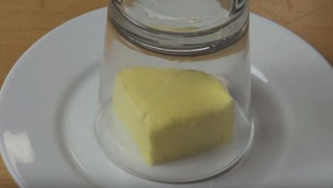 VIDEO! A pus un pahar gol peste o fafurie cu unt! În doar câteva secunde, apa fierbinte a transformat trucul într-un miracol!