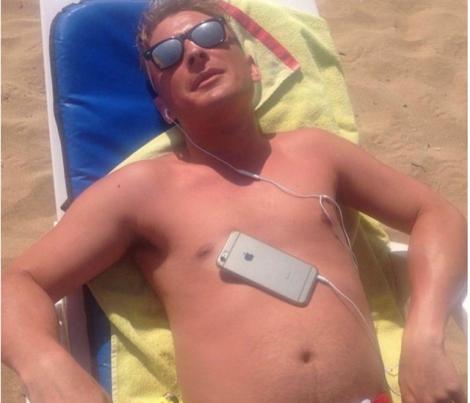 Imagini virale! A adormit cu telefonul pe piept la plajă. Ce s-a întâmplat cu bărbatul după întrece orice imaginaţie