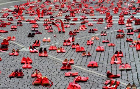 Sute de pantofi roşii, înşiraţi unul lângă altul. Motivul acestui gest este unul dureros