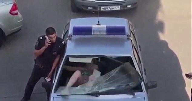 Ce se mai &icirc;nt&acirc;mplă &icirc;n Rusia. O femeie &icirc;n costum de baie, arestată, sparge parbrizul mașinii de poliție