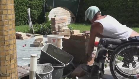 VIDEO! Lecție de viață: E &icirc;n scaun cu rotile, dar zidește case. A fost filmat &icirc;n timp ce muncea și a st&acirc;rnit admirația tuturor