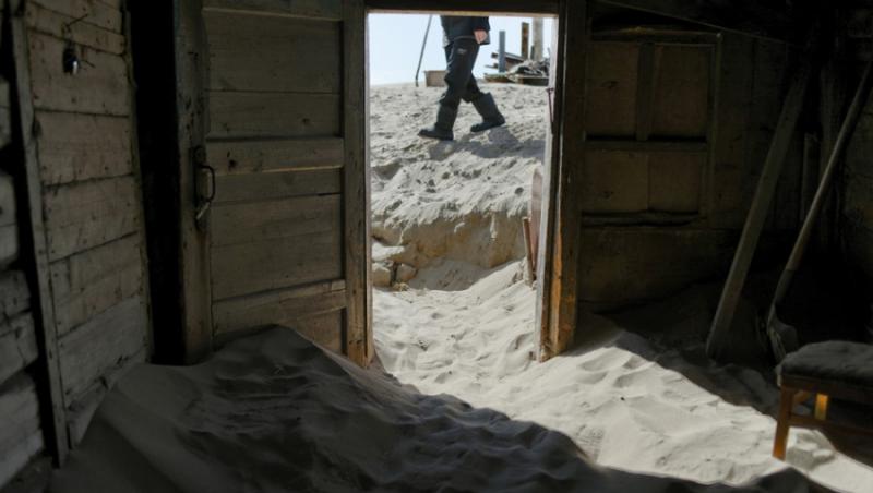 O galerie foto cum nu ai văzut! În satul pescăresc Șoina, cătunul înghițit de nisip, oamenii sunt îngropați de vii sub dunele aurii
