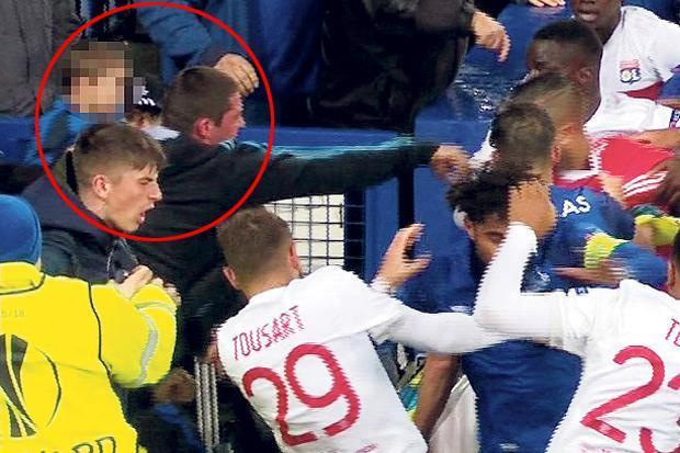 VIDEO: Scene șocante la meciul Everton-Lyon. Cu copilul &icirc;n brațe, un fan al englezilor lovește un jucător al oaspeților. Se cere suspendarea pe viață