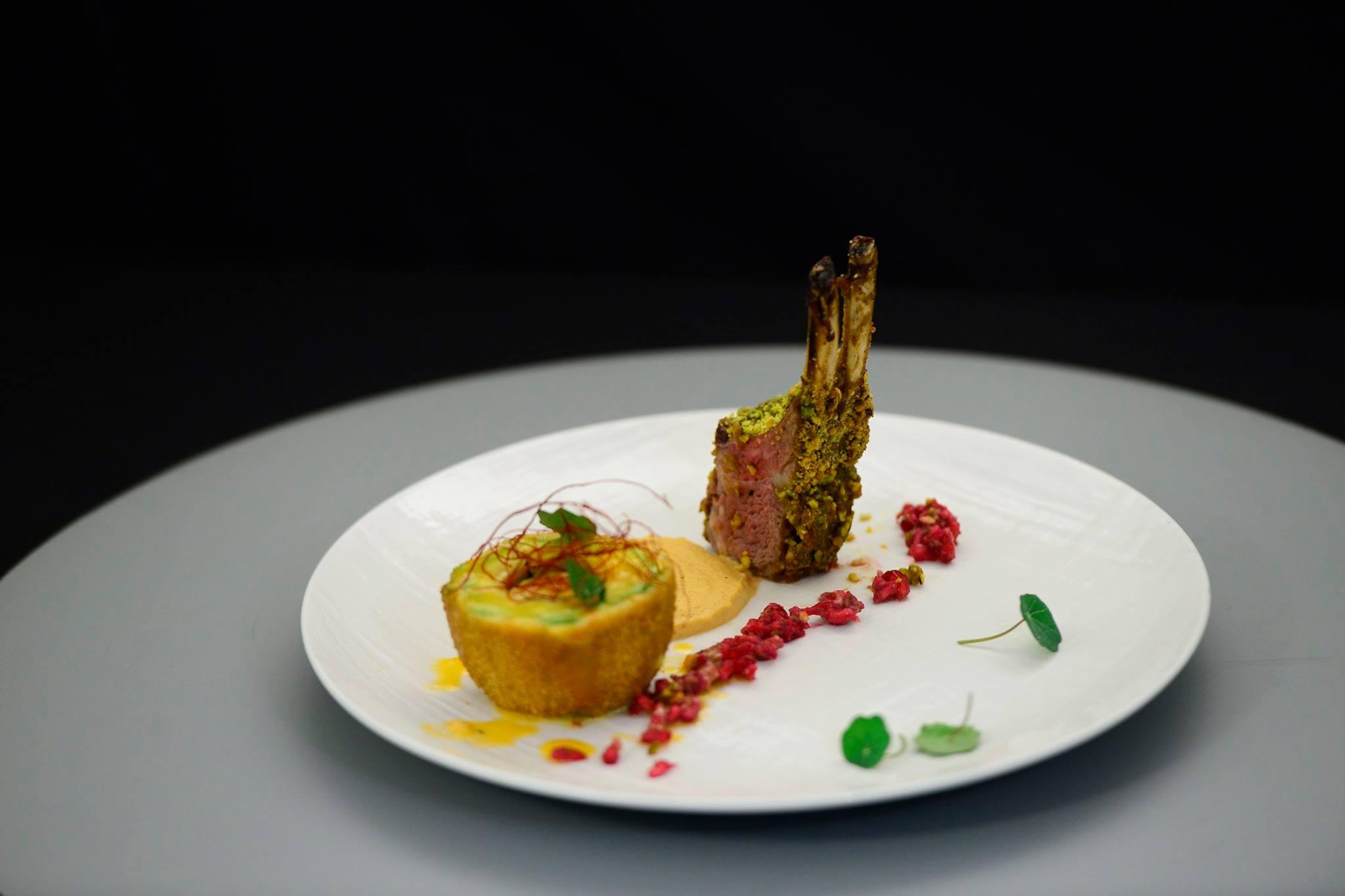 Cotlet de miel &icirc;n crustă de fistic și garnitură de avocado umplut cu br&acirc;nză cedar, sos de alune și sos de rodii