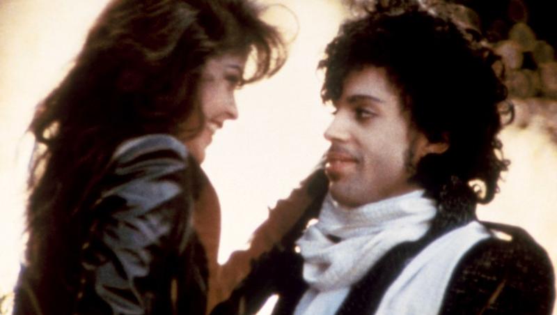 Acum un an, o lume întreagă îl plângea pe Prince, cel care ne-a adus ”PURPLE RAIN”. Povestea legendarei melodii și a femeii care apare în film
