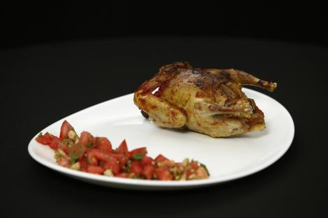 Porumbel umplut cu orez și măruntaie servit cu o salată de roșii cu mărar și nuci