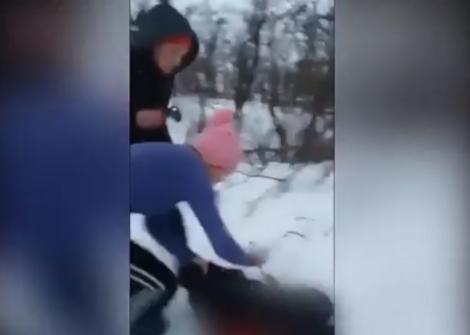 Bătaie cruntă! O elevă este călcată în picioare de alte două colege, pe un câmp. Trântită în zăpadă și lovită sistematic, fata plânge de durere: "O omor!"
