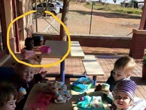 Imaginea care îți rupe sufletul! O fetiță de culoare, lăsată să mănânce singură, la masă, într-o grădiniță. Niciun copil nu s-a așezat lângă ea