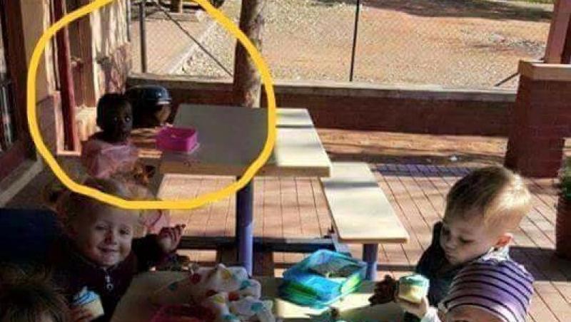 Imaginea care îți rupe sufletul! O fetiță de culoare, lăsată să mănânce singură, la masă, într-o grădiniță. Niciun copil nu s-a așezat lângă ea