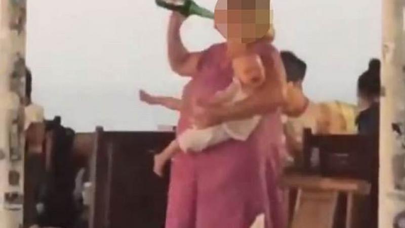 Imagini scandaloase surprinse pe terasa unui club! Nu lasă sticla din mână, chiar dacă bebelușul din brațe plânge de mama focului! Imaginile șocante au stârnit isterie pe internet: ”E revoltător!”