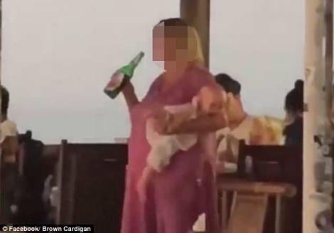 Imagini scandaloase surprinse pe terasa unui club! Nu lasă sticla din mână, chiar dacă bebelușul din brațe plânge de mama focului! Imaginile șocante au stârnit isterie pe internet: ”E revoltător!”
