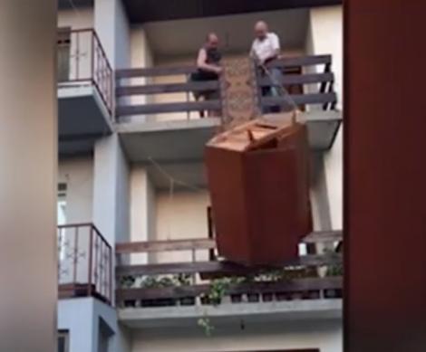 VIDEO VIRAL. Imaginile cu doi bărbaţi care încearcă să coboare un şifonier de la etajul doi al unei clădiri fac furori pe Internet. RÂZI CU LACRIMI!