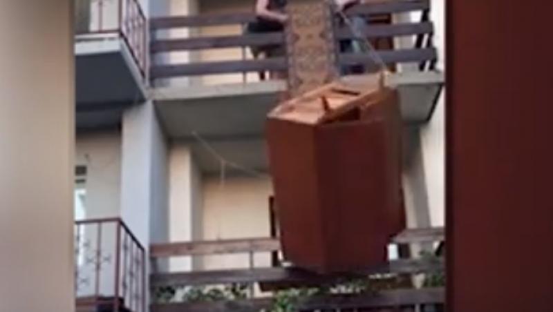 VIDEO VIRAL. Imaginile cu doi bărbaţi care încearcă să coboare un şifonier de la etajul doi al unei clădiri fac furori pe Internet. RÂZI CU LACRIMI!