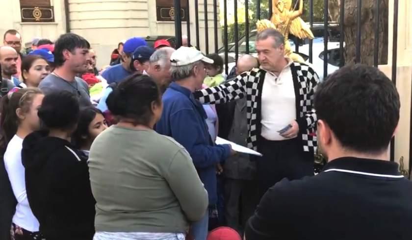 Gigi Becali a &icirc;mpărțit un teanc cu bancnote de 100 de lei, &icirc;n stradă, &icirc;n fața palatului din București