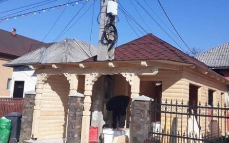 Nu există așa ceva! Un român și-a ridicat casă de lemn în jurul unui stâlp de electricitate
