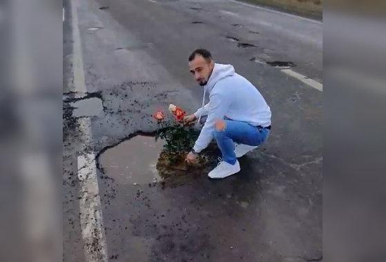 VIDEO/ Fără gropi nu se poate! Doi tineri au plantat trandafiri &icirc;ntr-o groapă de pe un drum național.  &bdquo;Dar asta e șosea? Nu prea arată&rdquo;