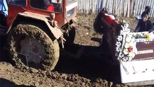 Video. Sicriu dus la groap&atilde; cu tractorul, &icirc;mpotmolit &icirc;n noroaie. Rudele mortului au &icirc;mpins mașina pentru a ajunge la cimitir