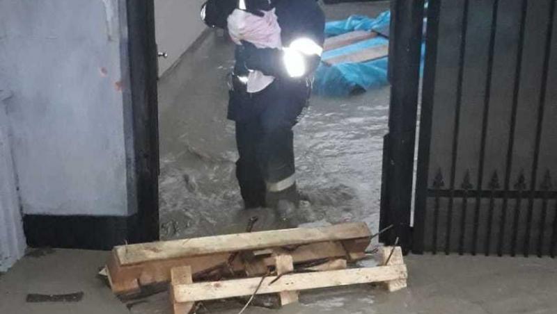 Potop în România. Un pompier ține în brațe un bebeluș abia născut, pentru a-l salva din calea apelor