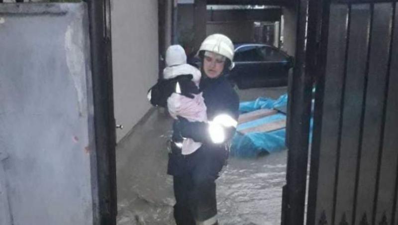 Povestea emoționantă din spatele pozei în care un pompier salvează un bebeluș dintr-o gospădărie inundată