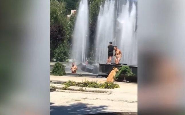 Două femei și un bărbat se răcoresc &icirc;n f&acirc;nt&acirc;na arteziană din centrul orașului Reșița VIDEO