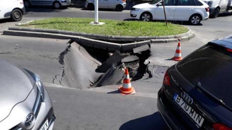 O mașină a fost înghițită de un crater pe o stradă din București! VIDEO