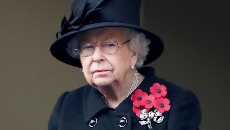 Regina Elisabeta a Marii Britanii, purtând o pălărie și o haină negre și o broșă cu flori