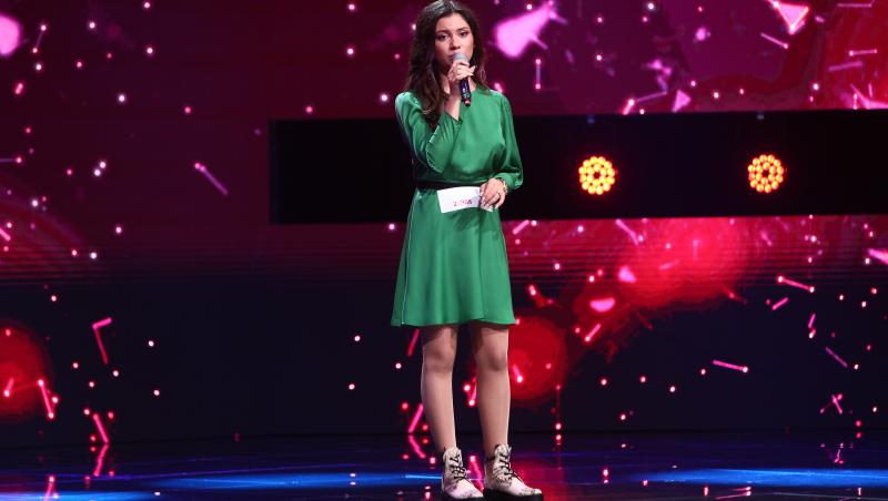 Andra Barangă, într-o rochie verde, interpretând melodia  "Run To You"