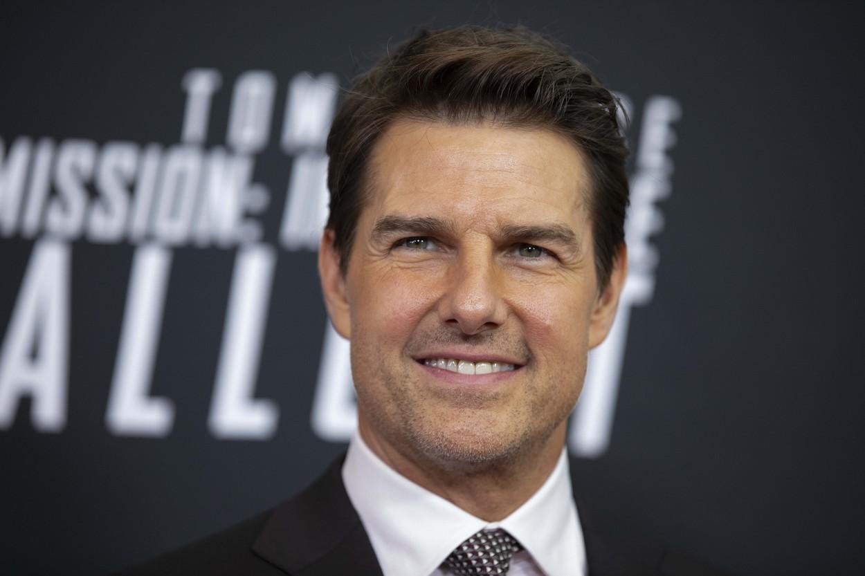 Tom Cruise pe covorul rosu, intr-un costum negru si camasa alba