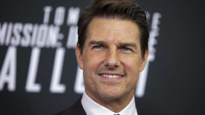 Tom Cruise pe covorul rosu, intr-un costum negru si camasa alba
