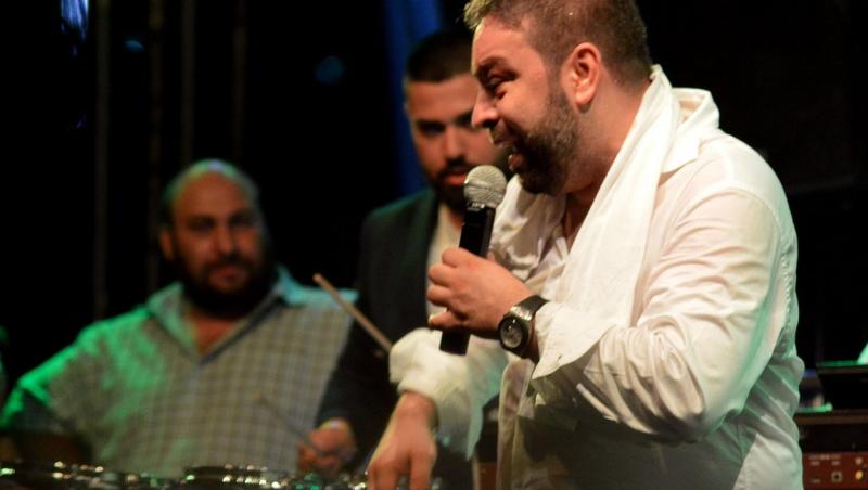 Florin Salam, într-o cămașă albă, la o cântare din 2017