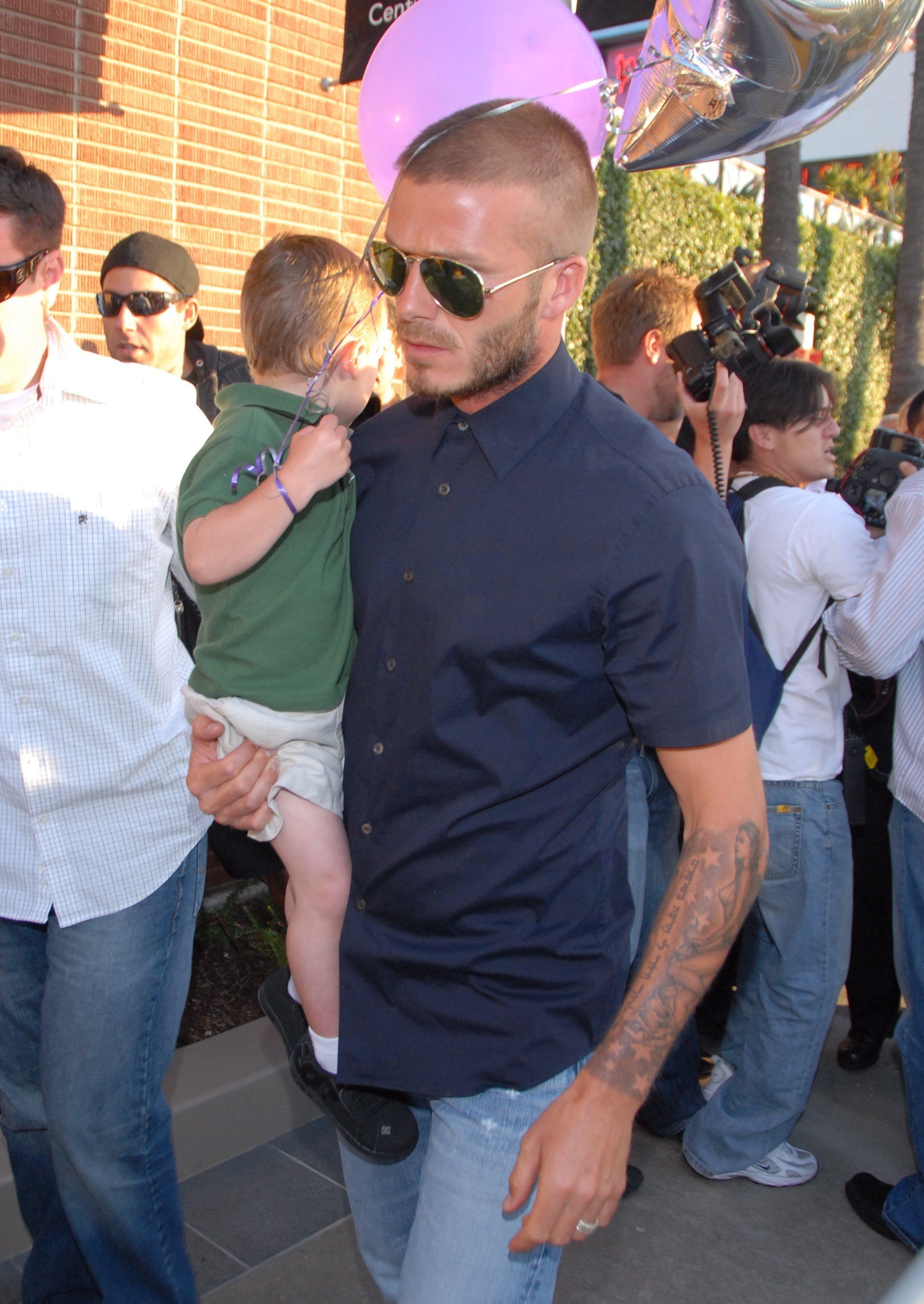 David Beckham, cu unul dintre copiii lui in brate, camasa neagra