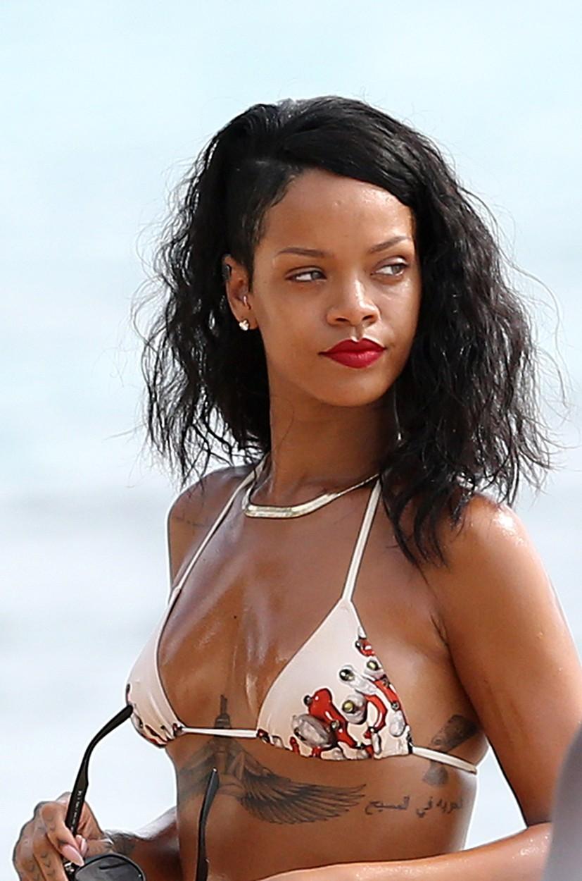 Rihanna poartă un costum de baie care îi lasă la vedere tatuajul de sub sâni