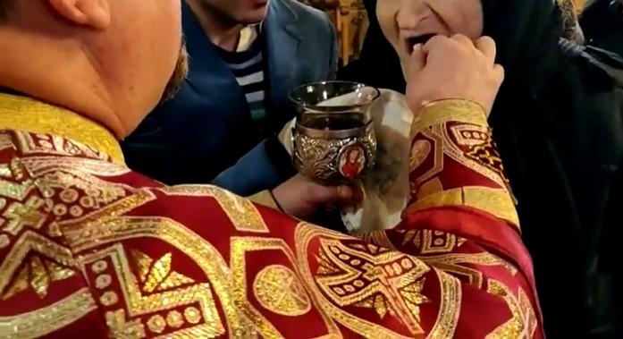 Inconștiență &icirc;n plină pandemie de coronavirus, chiar &icirc;n fața altarului! Un preot a &icirc;mpărtășit enoriașii direct cu m&acirc;na - Video