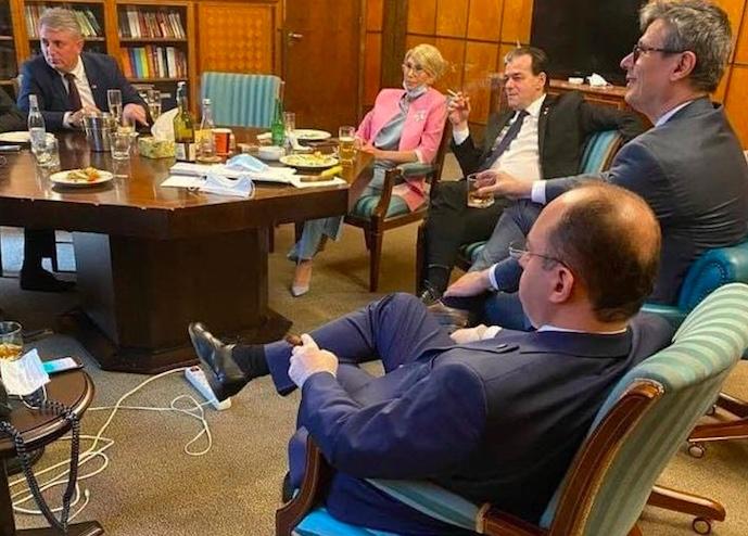 Fotografie virală cu premierul Orban şi mai mulţi miniştri care beau, fumează şi mănâncă într-un birou al Guvernului. Nimeni nu poartă mască!