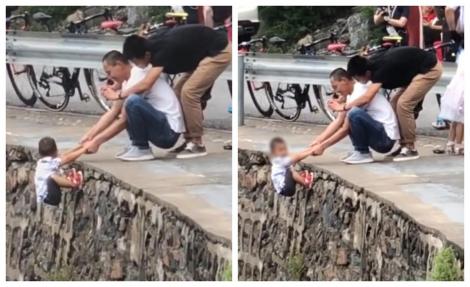 Și-a atârnat copilul de marginea prăpastiei, ca să aibă de ce să râdă! Imagini uluitoare! VIDEO