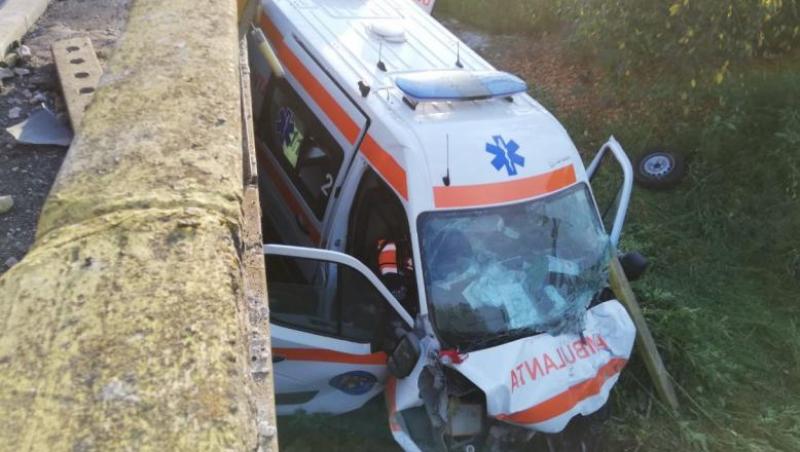 FOTO | O ambulanță în care se afla un pacient COVID s-a răsturnat pe un pod în urma unei coliziuni violente cu un alt autoturism
